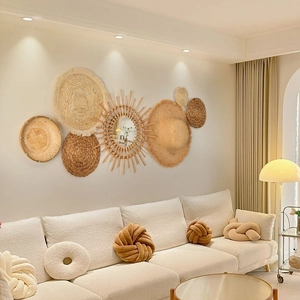 Detailed close-up of bohemian straw wall decor set with woven baskets and round mirror