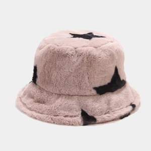 Detail of soft plush bucket hat featuring black star patterns on beige faux fur fabric