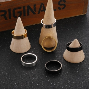 Close-up of minimalist 6mm polished titanium steel rings in gold, silver, and black finish
