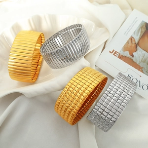 Minimalistische goldene und silberne Stretch-Armbänder mit Karomuster auf Schale