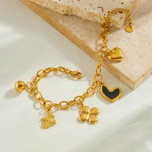 Gold plated stainless steel charm bracelet featuring bee, clover and black heart charms