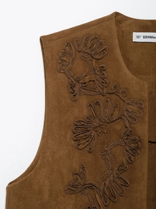 Detailed view of floral embroidery on a brown faux suede bohemian vest jacket