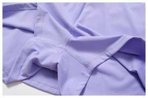 Macro shot of flatlock stitching on elastic lavender knit fabric of the athletic dress