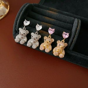 Détail des boucles d'oreilles ours en zircon en forme de cœur, finitions or et argent