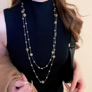 Close-up of double-layer beaded necklace with clear and champagne crystals on a model