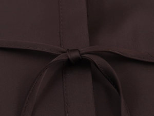 Gros plan d'une chemise en satin marron foncé avec texture sergée et ceinture