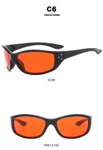 Detail view of Y2K cycling sunglasses with orange lenses and silver stud accents