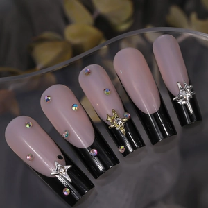Y2K star nail charms on pink French tips with iridescent rhinestones and 3D metal stars