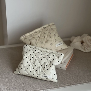 Detailed shot of quilted corduroy makeup bags in floral and heart patterns