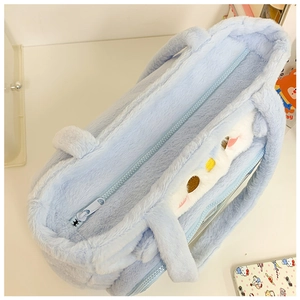 Close-up of the light blue plush shoulder bag showing the zipper and soft furry texture