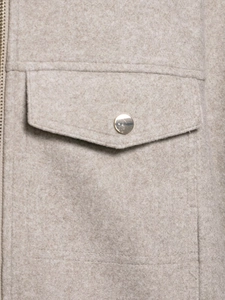 Detailed macro view of soft beige woolen bomber jacket with golden button and flap pocket