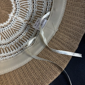 Close-up of the knitted bucket hat interior showing adjustable drawstring and care label