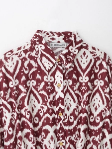 Close-up of red retro printed shirt showing cotton-linen texture and wooden buttons