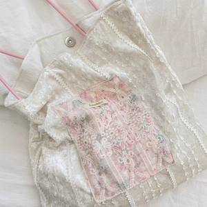 Detailed view of cream velvet tote with pink floral lace pocket and magnetic clasp