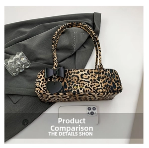 Detailed view of leopard print tote bag with bow charm and smartphone for scale reference