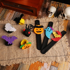 Halloween slap bracelets with pumpkin and bat designs on a rustic wooden table