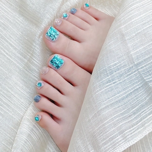 Dettaglio di unghie finte piedi blu Tiffany con strass di lusso e glitter argento