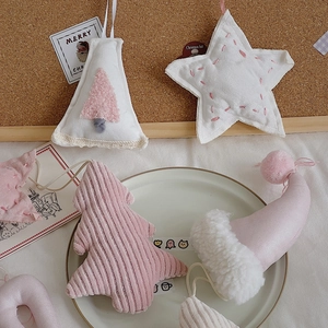 Detailed view of pink and white plush Christmas ornaments made of corduroy and faux fur
