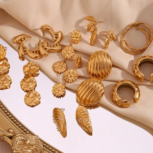 Collection of gold earrings with pearls on champagne silk and mirror surface