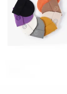 Close-up of vibrant winter knit beanies featuring detailed smiley face embroidery