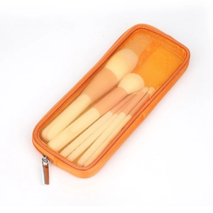 Pochette per trucco in rete arancione con set di pennelli cosmetici su sfondo bianco