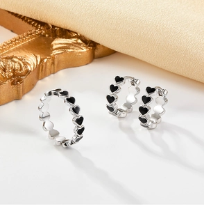 Detail of 925 silver jewelry set with black enamel hearts including ring and earrings
