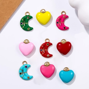 Macro shot of colorful enamel heart and moon charms with rhinestones for DIY jewelry