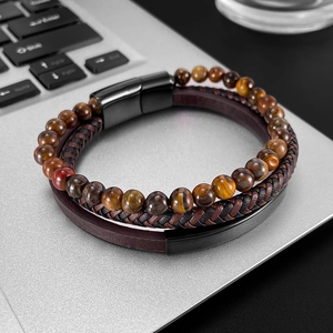 Detailed macro of men's multi-layer leather bracelet with tiger eye beads and magnetic clasp