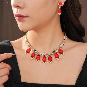 Close-up of a vintage golden jewelry set featuring red teardrop gems and bowknot details