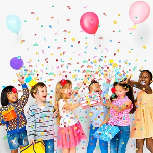 Grupo de niños alegres celebrando con coloridos confeti metálicos de Happy Birthday