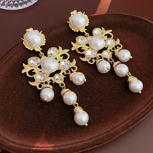 Detailed close-up of Baroque vintage drop earrings with pearls and crystal rhinestones