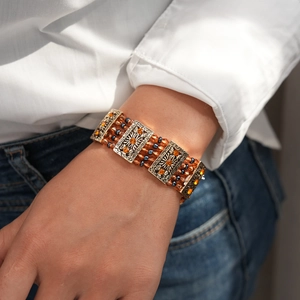 Detail of vintage bohemian bracelet with orange rhinestones and bronze carvings