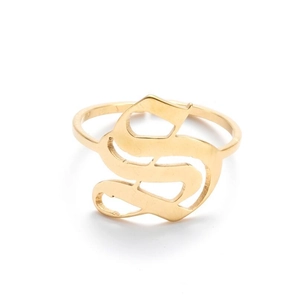 Macro detail of golden gothic letter S ring with polished vintage aesthetic surface