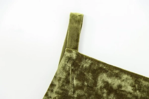 Close-up of olive green velvet top showing thin shoulder strap stitching and fabric texture