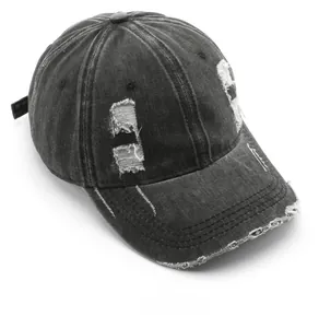 Detail shot of distressed cotton baseball cap showing washed denim fabric and ripped texture