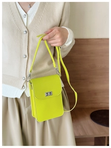 Detail of neon yellow mini crossbody bag with cross-grain texture and silver metal lock