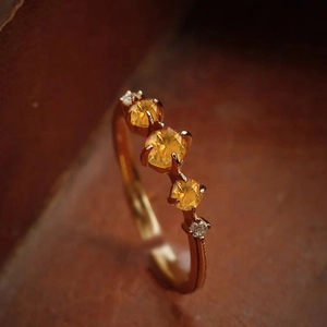 Detailed macro view of S925 silver ring featuring three yellow stones and rose gold finish