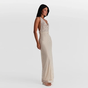 Detail of beige polka dot maxi dress with backless cut and elegant halter neckline