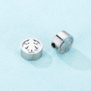 Detail view of two silver stainless steel beads with a cutout girl design for DIY jewelry