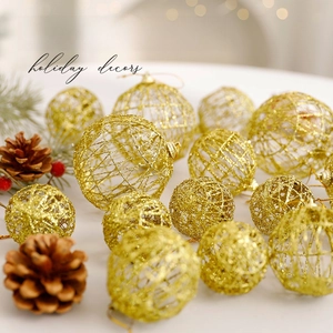 Bolas de Navidad huecas tejidas en oro con purpurina sobre fondo de pino festivo