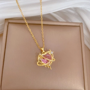 Elegant gold titanium necklace featuring a pink crystal heart planet pendant on silk fabric