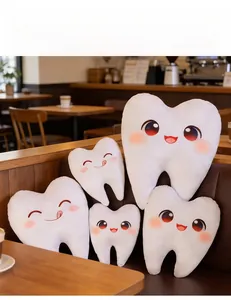 Gros plan de coussins en peluche en forme de dent avec des expressions mignonnes