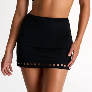 Close-up of black tight mini skirt with geometric laser-cut hollow pattern and high waist