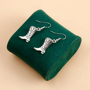 Détail des boucles d'oreilles bottes de cowboy en argent avec gravures vintage