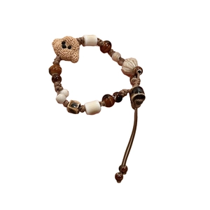 Handmade beaded bracelet with ceramic charms, tiger eye stones, and a cute teddy bear pendant