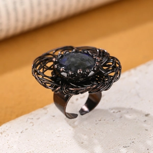 Macro shot of handcrafted bronze wire-wrapped bird nest ring with natural labradorite stone