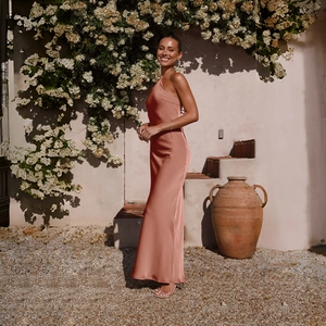 Detail of elegant dusty rose satin halter dress showing backless design in sunlight