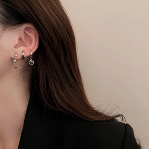 Detailed view of silver heart earring set worn by a model in professional styling
