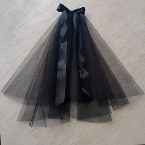 Elegant multi-layer black bridal veil with a satin bow knot on marble background