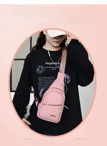 Detail of pink quilted nylon crossbody bag with gold zippers and metal logo on a model
